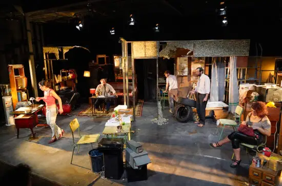 Escena de la obra, con el reparto en la escenografía.