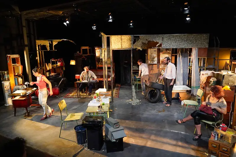 Escena de la obra, con el reparto en la escenografía.